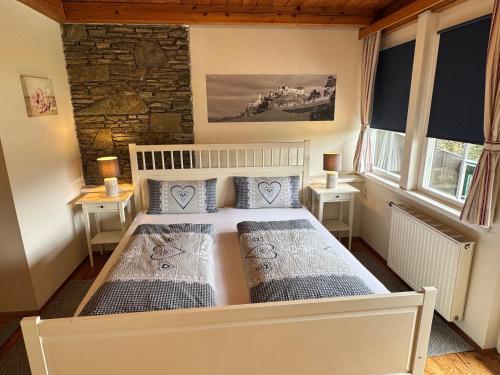 a bedroom with two beds and two windows at Landhaus Klopein in Sankt Kanzian