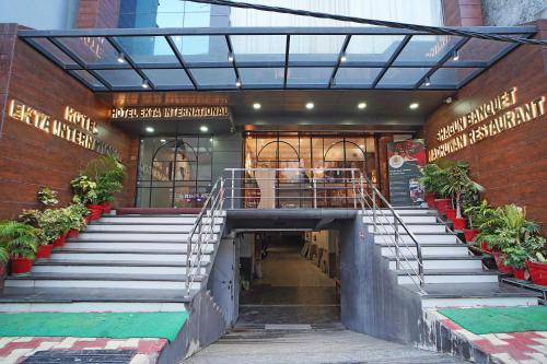 a stairway in a building with stairs and plants at Hotel Ekta International !! 300 Mts From BABA BAIDYANATH DHAM TEMPLE !! in Deoghar