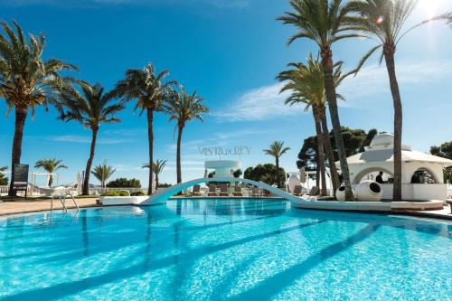 a pool at a resort with palm trees at Hilton Mallorca Galatzo in Paguera