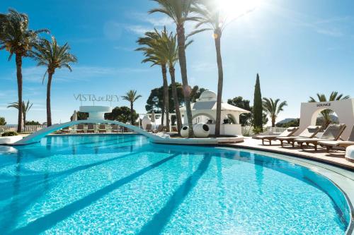 a pool at a resort with palm trees at Hilton Mallorca Galatzo in Paguera