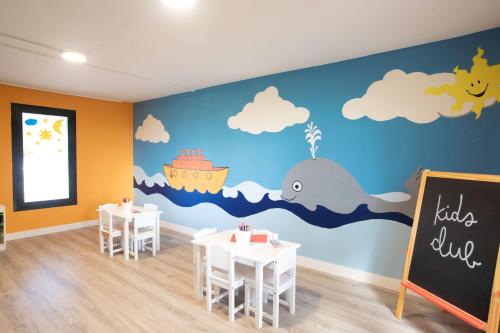a classroom with tables and a whale mural at Hilton Mallorca Galatzo in Paguera