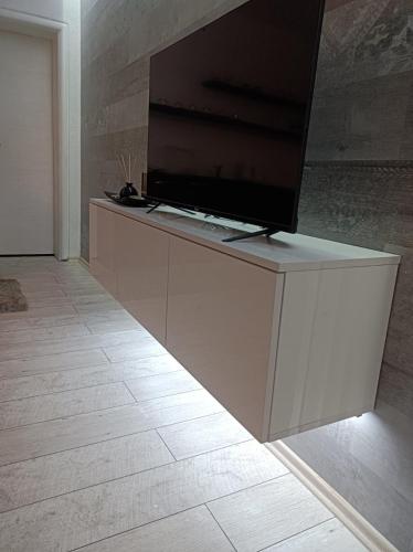 a flat screen tv sitting on top of a cabinet at Cozy apartment with garden in Sarajevo