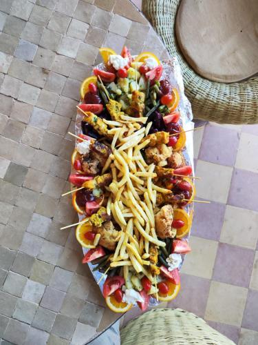 a tray of hot dogs with french fries and other foods at Kanz Erremal in Merzouga