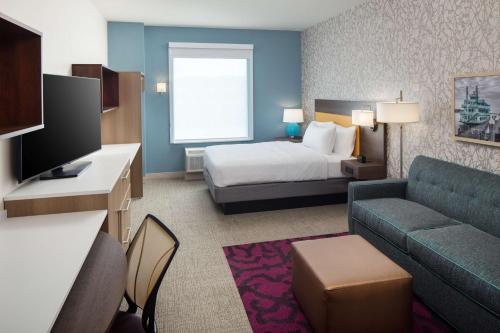 a hotel room with a bed and a couch at Home2 Suites By Hilton Wilmington Medical Park Downtown in Wilmington