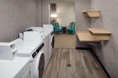 a laundry room with white appliances and blue chairs at Home2 Suites By Hilton Wilmington Medical Park Downtown in Wilmington