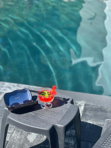 a table with a cell phone and a bowl on it next to a pool at Stupari in Shaian