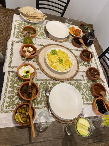 a table with plates and bowls of food on it at Seleucia DaR Umm Qais in Um Qeis