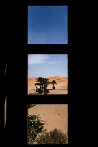 a window view of the desert seen through a window at Kanz Erremal in Merzouga