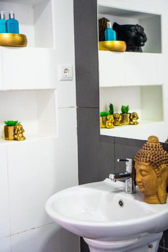 La salle de bains est pourvue d'un lavabo et d'une statue. dans l'établissement Morabezahome - Zaza, à Mindelo