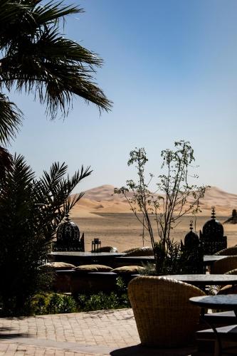 a view of the desert from a park with tables and chairs at Kanz Erremal in Merzouga