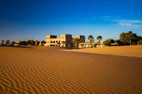 a building in the middle of a desert at Kanz Erremal in Merzouga