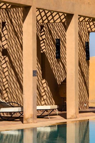 a shadow of a building with a swimming pool at Kanz Erremal in Merzouga