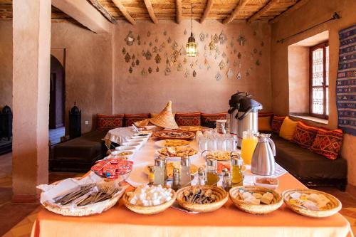 a table with many baskets of food on it at Kanz Erremal in Merzouga