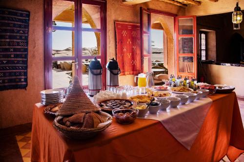 a table with a buffet of food on it at Kanz Erremal in Merzouga
