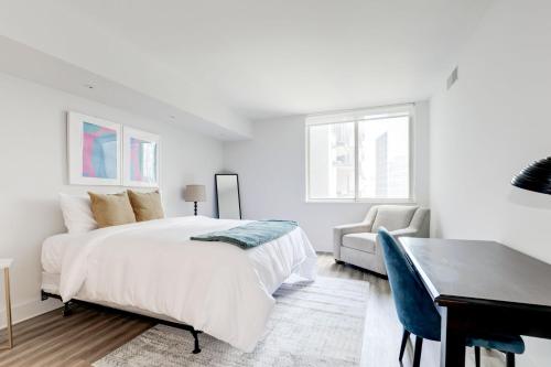 a white bedroom with a bed and a desk at Elegant 2BR Apartment Minutes From DC in Arlington