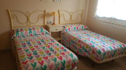 dos camas sentadas una al lado de la otra en un dormitorio en Victoria, en Cádiz