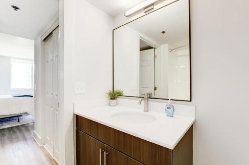 a bathroom with a sink and a mirror at Elegant 2BR Apartment Minutes From DC in Arlington