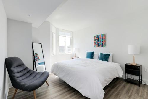 a white bedroom with a bed and a chair at Jetsetter's 2BR Hub Between DC & Airport in Arlington