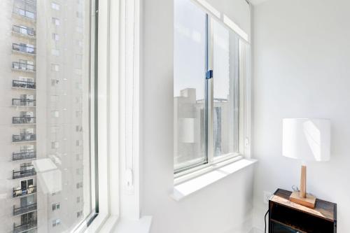 a white room with a window and a table with a lamp at Jetsetter's 2BR Hub Between DC & Airport in Arlington