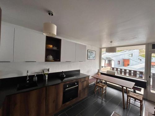 une cuisine avec un évier et une table à l'intérieur dans l'établissement Appart rénové, 2 chambres + cabine, skis aux pieds - FR-1-641-23, à Tignes
