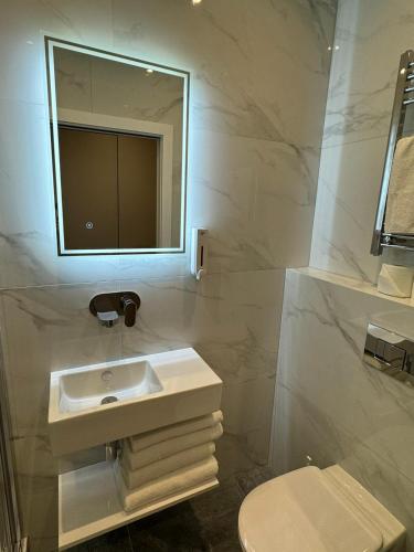 a white bathroom with a sink and a mirror at Victoria Studios in London