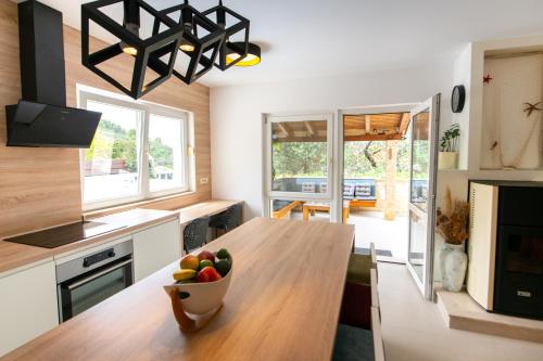 a kitchen with a wooden table with a bowl of fruit on it at Villa Lipovac Trogir in Trogir