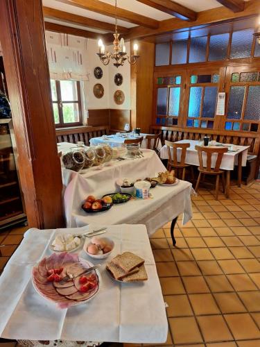 a dining room with two tables with plates of food at Hôtel à la croix d'or in Sessenheim