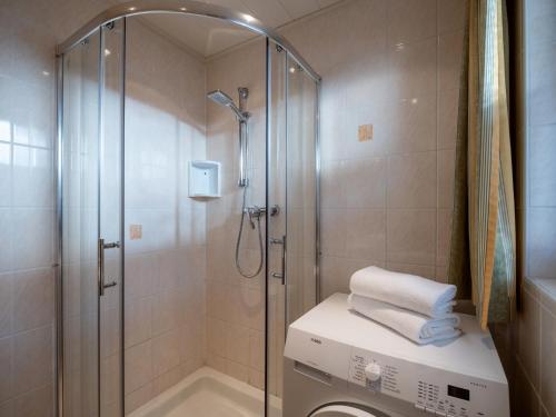 ein Bad mit einer Dusche und einer Waschmaschine in der Unterkunft Appartement Robert - by NV-Appartements in Kirchberg in Tirol