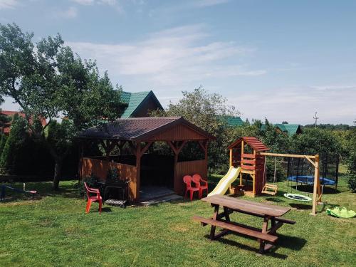 een speeltuin met een prieel en een glijbaan bij Apartament Leona in Ostrowo