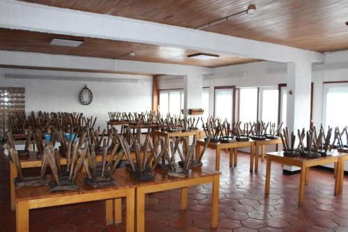 ein Raum voller Holztische mit Schwertern in der Unterkunft Le Pourquoi Pas in Saint-Lary-Soulan