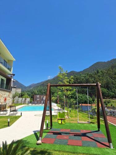a swing set in a yard next to a pool at Gerês Valley in Geres