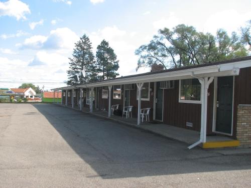 an empty building with a porch with chairs in it at Spinning Wheel Motel in Baraboo