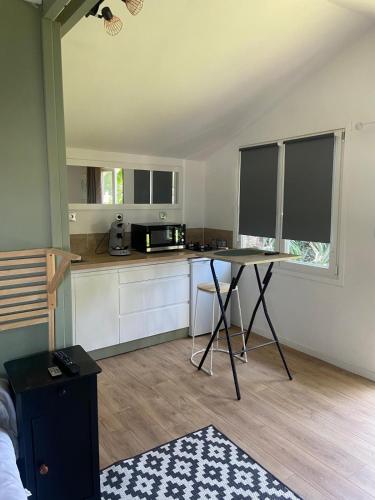 - une cuisine avec une table au milieu d'une pièce dans l'établissement Cottage Bohème - Voyageur Solo - Jardin Partagé, à Perros-Guirec