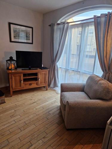 a living room with a couch and a flat screen tv at The Downshire Arms Apartments Hilltown in Newry