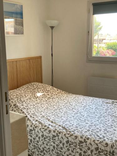 une chambre avec un lit avec une lampe et une fenêtre dans l'établissement Le Ciel Bleu, à La Seyne-sur-Mer