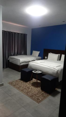 two beds in a room with a blue wall at The Turk Boutique Hotel in Durban