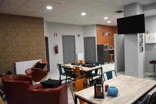 une chambre avec des tables et des chaises ainsi qu'une cuisine dans l'établissement Albergue Bide-Ona, à Portugalete