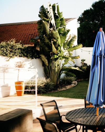 a patio with a table and a blue umbrella at Casa francesa de Piraju in Piraju