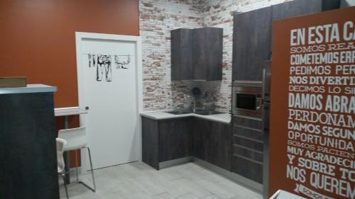 a kitchen with a brick wall and a white door at Albergue Bide-Ona in Portugalete