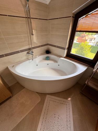 a large white tub in a bathroom with a window at Sarajevo Villa Ruza Vjetrova in Vinogradi