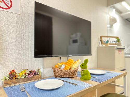a table with plates and a basket of food on it at nestay inn tokyo ueno in Tokyo