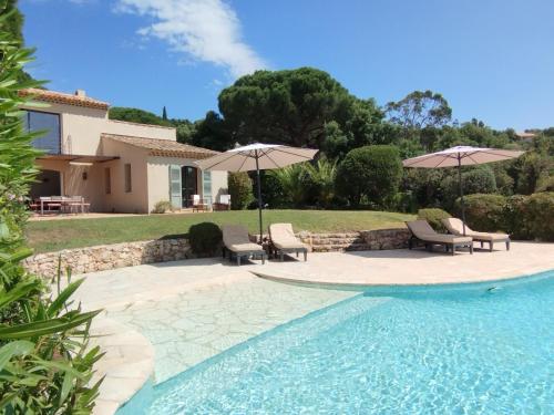 une piscine avec chaises et parasols dans une cour dans l'établissement villacoucourelle saintemaximecom quiet near beach & center with sea and garden views, à La Garonnette-Plage