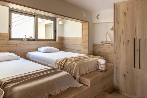 a bedroom with two beds and a window at Casa Meraki by A&D Properties in Porto Rafti