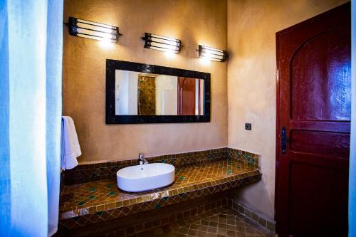 a bathroom with a sink and a mirror at Kanz Erremal in Merzouga