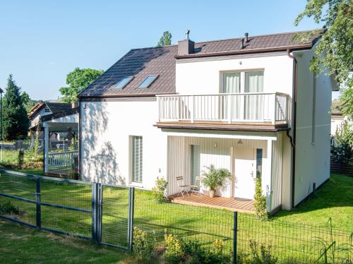 a white house with a balcony and a yard at Leo House in Gdynia