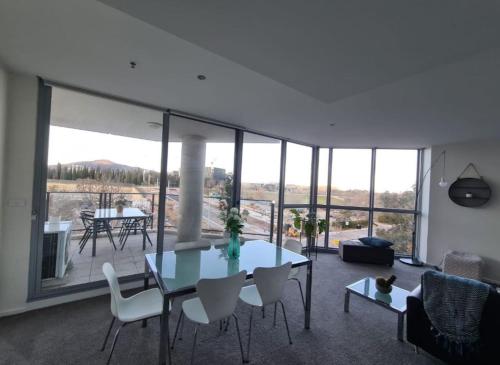 una sala de estar con una mesa y sillas en Grand 2BR between ANU and City - Hosted by Canstay, en Canberra