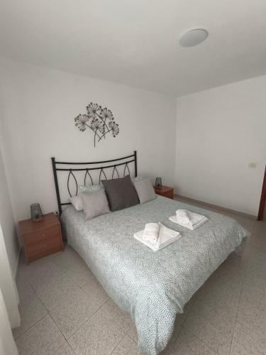 a bedroom with a bed with two towels on it at Cheyma Home 2ºA, Luminoso apartamento en Alcalá in Alcalá
