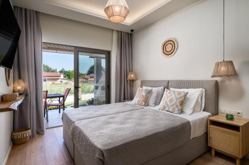 een slaapkamer met een bed en een glazen schuifdeur bij Phos Elegant Residences by Konnect, 400m to the beach in Dassia