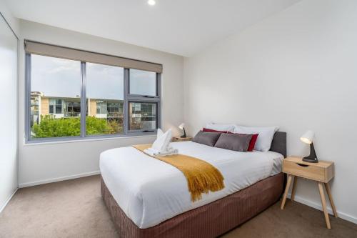 een slaapkamer met een groot bed en een raam bij Kingston Foreshore with Garden View - Hosted by Canstay in Kingston 