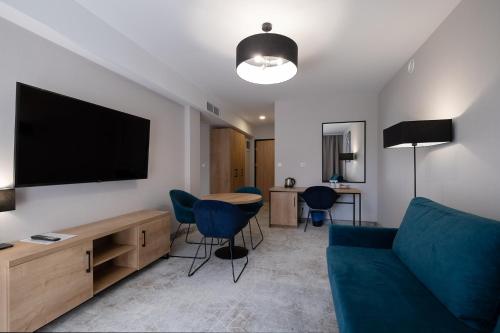 a living room with a couch and a flat screen tv at Hotel Jarzębata in Wisła